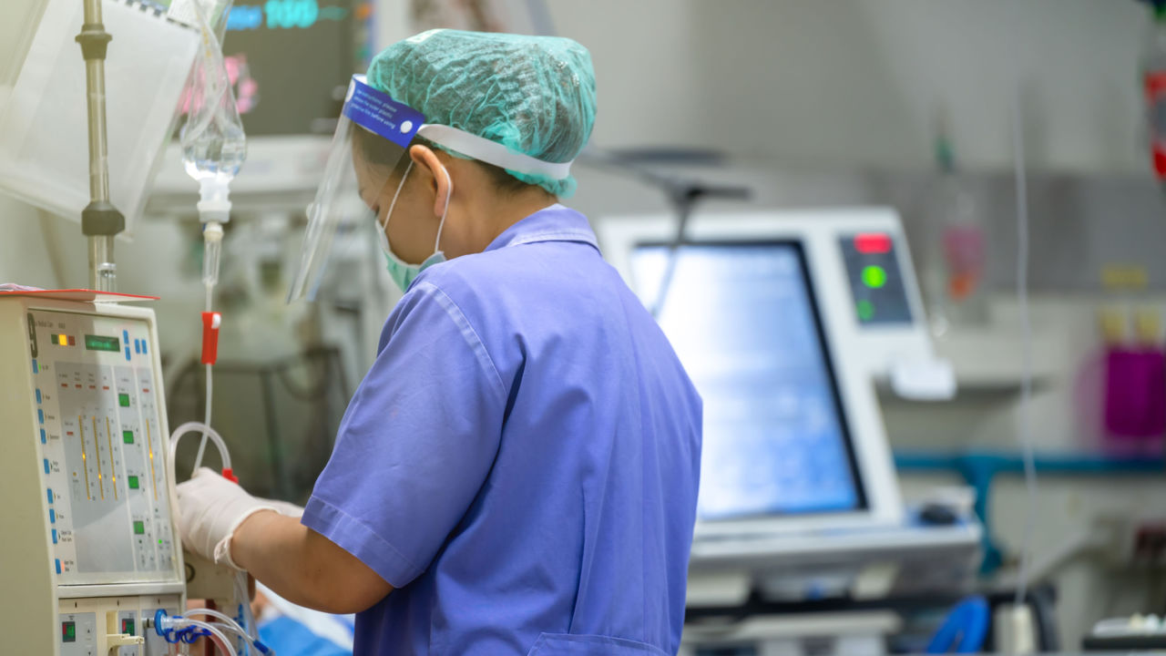 Photo of a technician at a hemodialysis machine