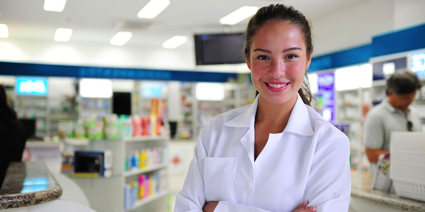 female Pharmacy Technician smiling and wearing white