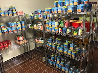 Food Pantry shevling stocked with various canned goods