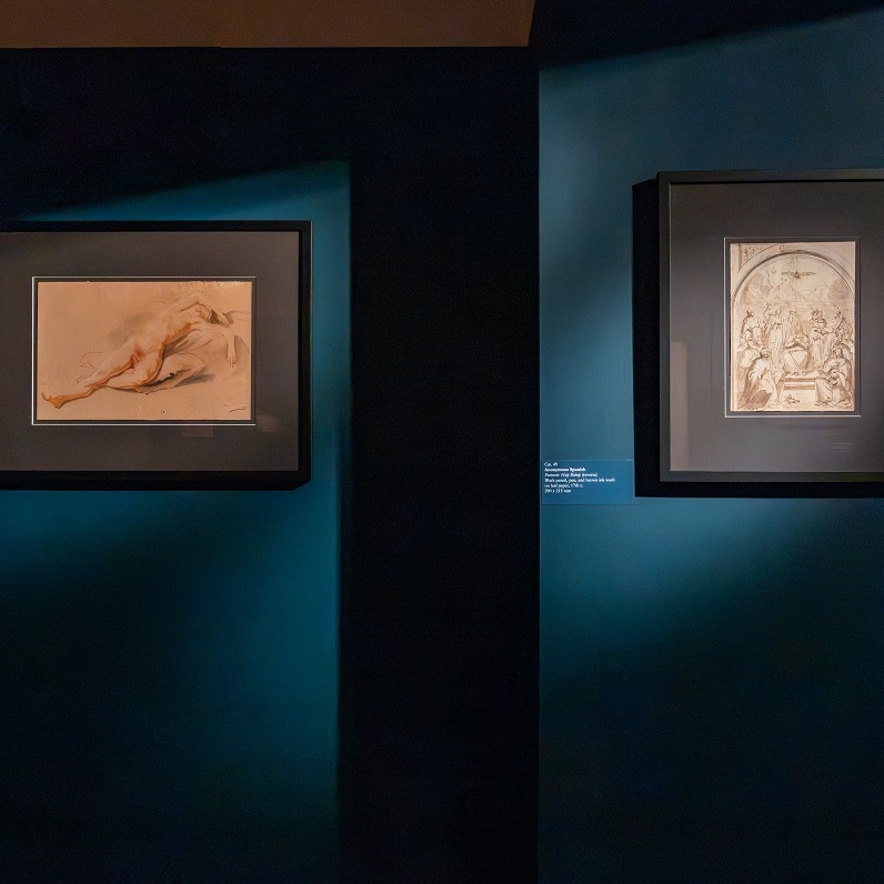 two paintings hanging on a dark wall