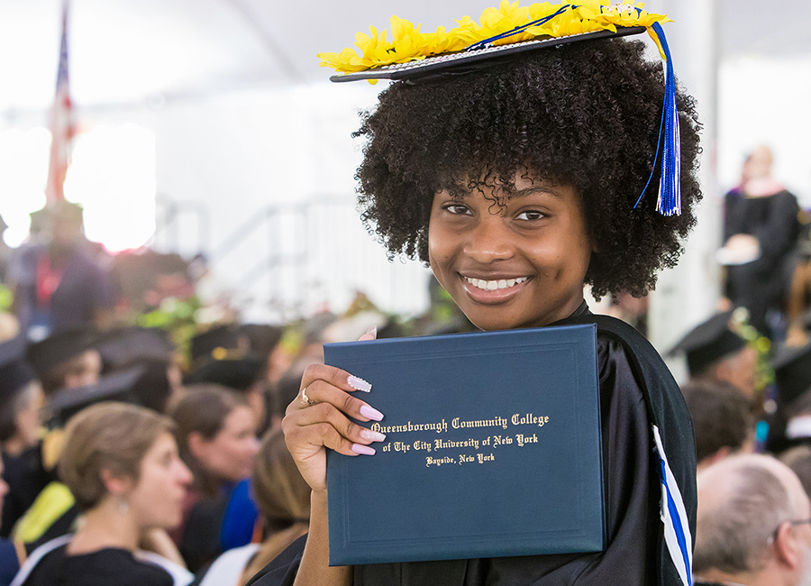 femal student at graduation holding up her diploma