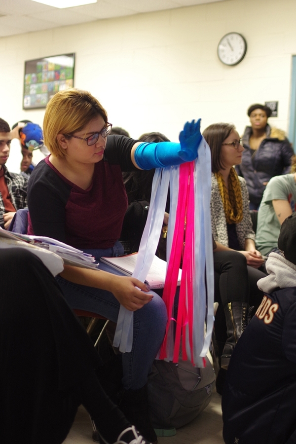 A student trying on one of the works of visiting artist Maria Hupfield