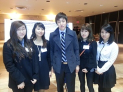 group of 5 students posing in front of presentation poster in 2013