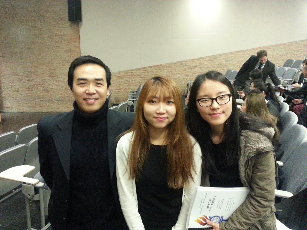 2 female and 1 male student in auditorium