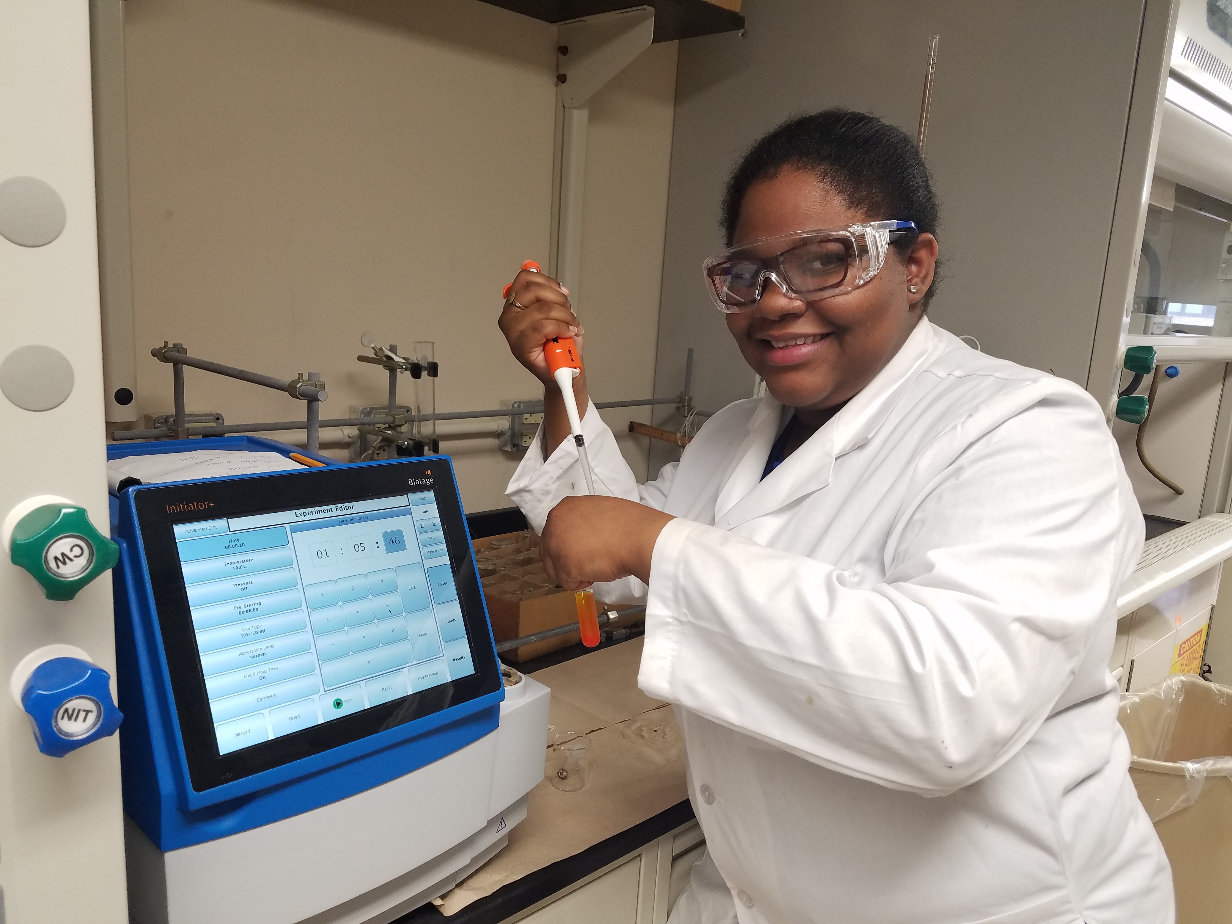 female student in lab holding a pipette