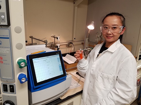 female student wearing lab coat and goggles 