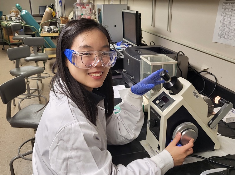 female student wearing lab coat and goggles 