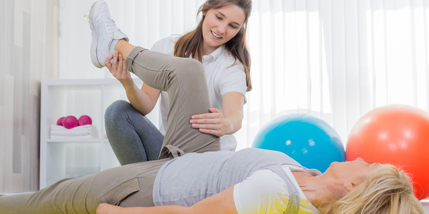 Physical therapist raising patient's leg