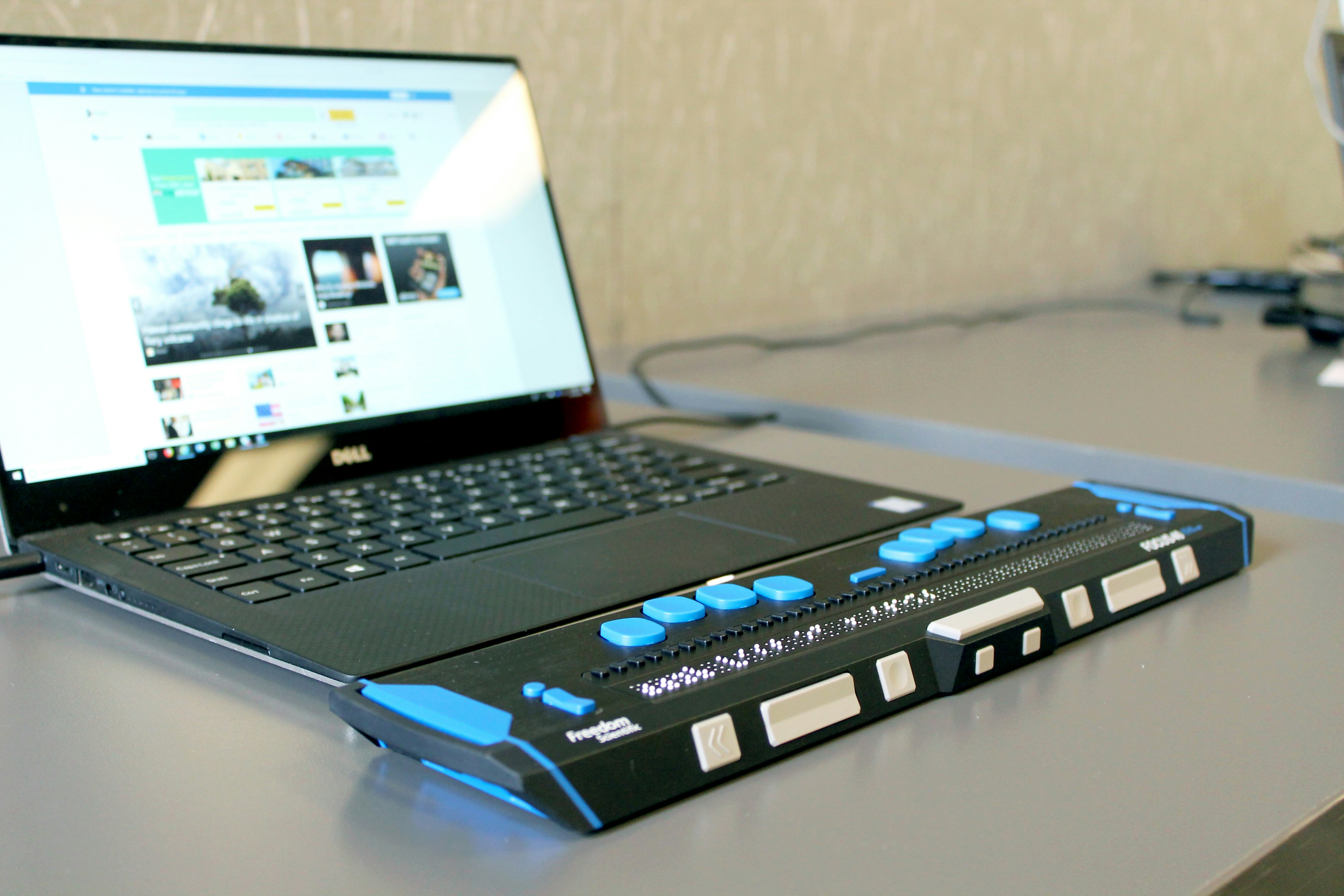 A laptop connected to a refreshable braille display