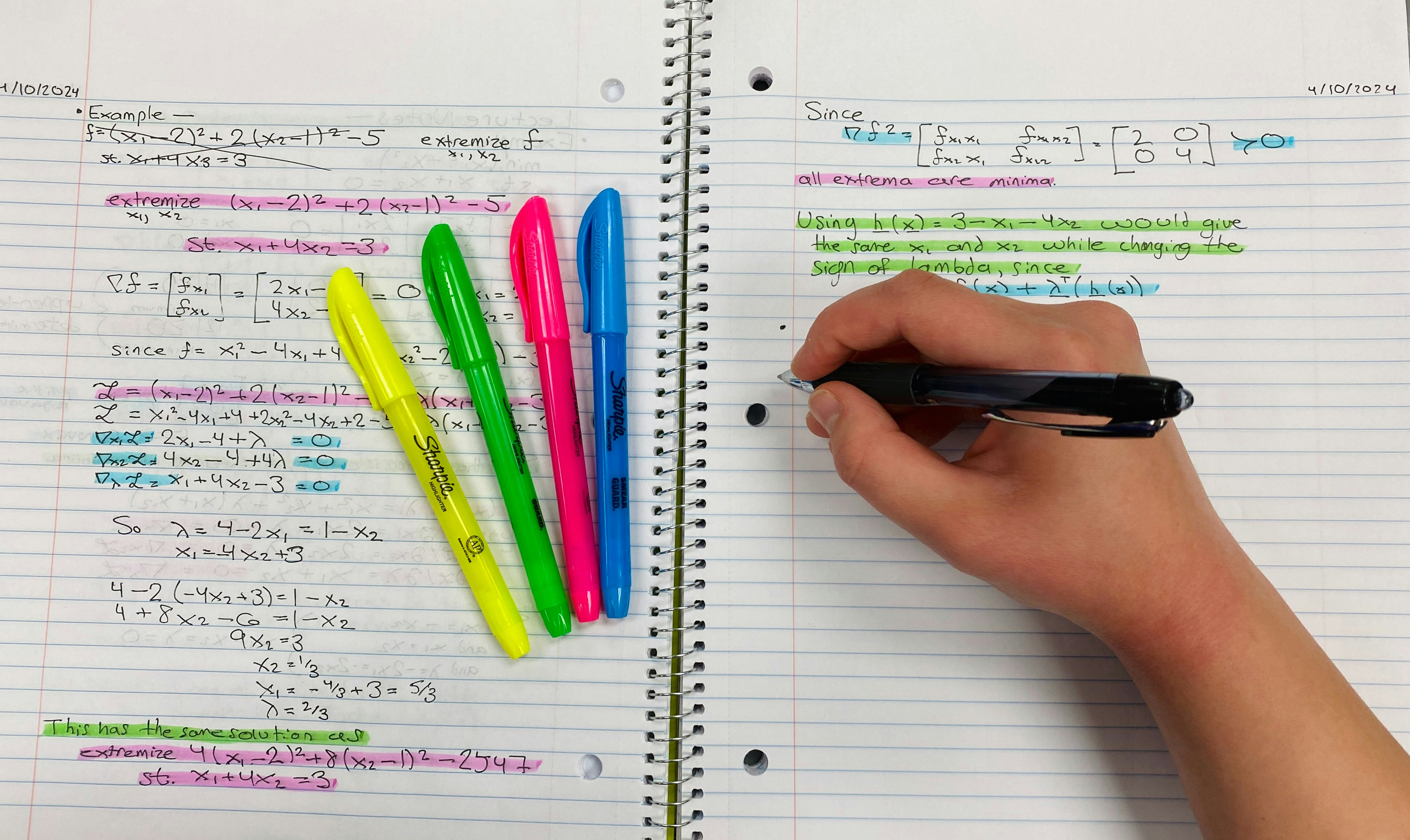 A student studying by solving math problems in a notebook