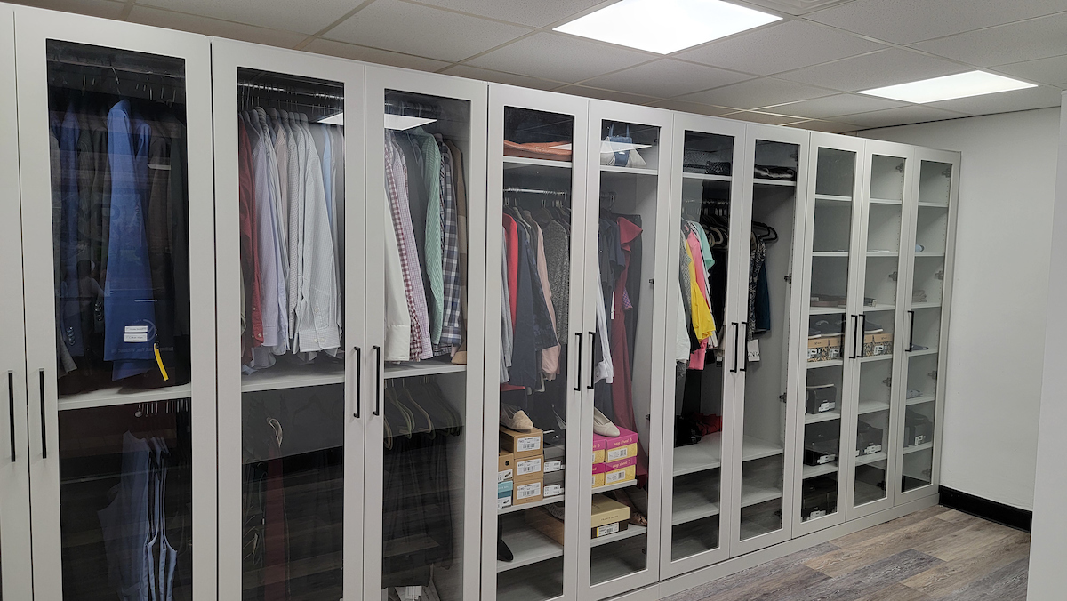 walk-in closet with glass panels and professional attire and accessories inside
