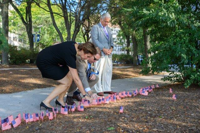 Dr. Timothy G. Lynch, center, joins staff in placing memorial flags.