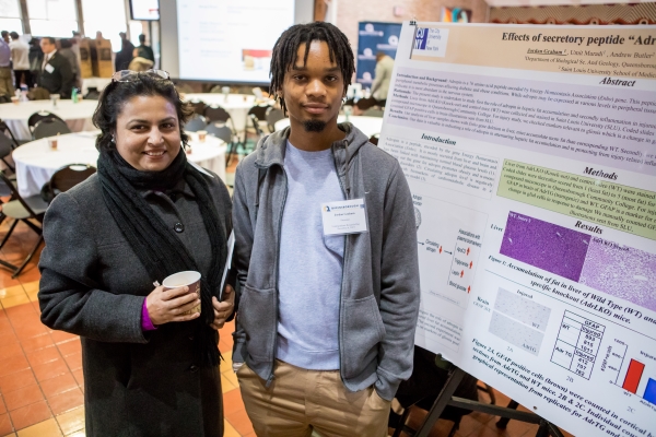 Sarbani Ghoshal with African male student Jordan Graham near poster at Research Fair