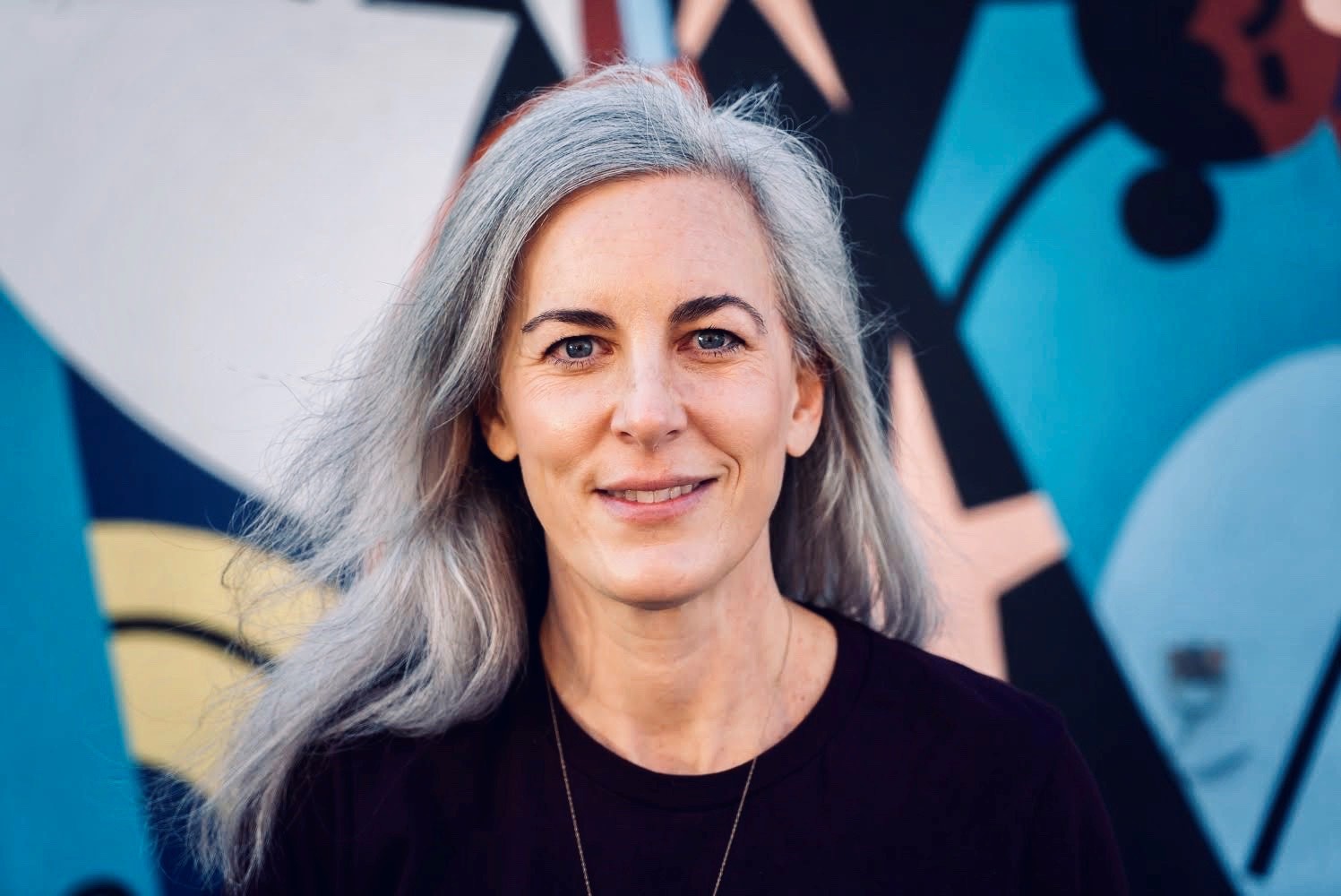 Dr. Elizabeth Toohey in black shirt, smiling