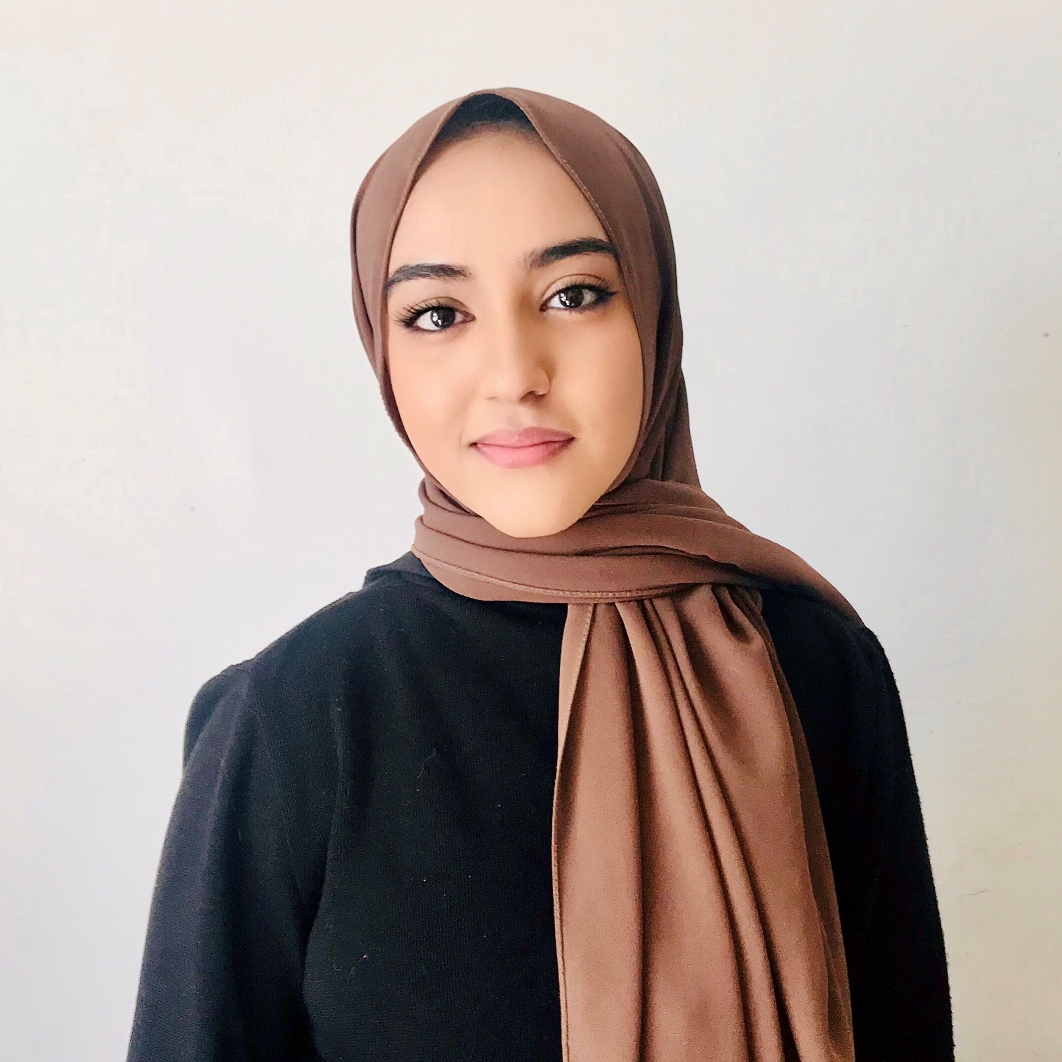 headshot of Asia Khan, wearing a hijab and black dress