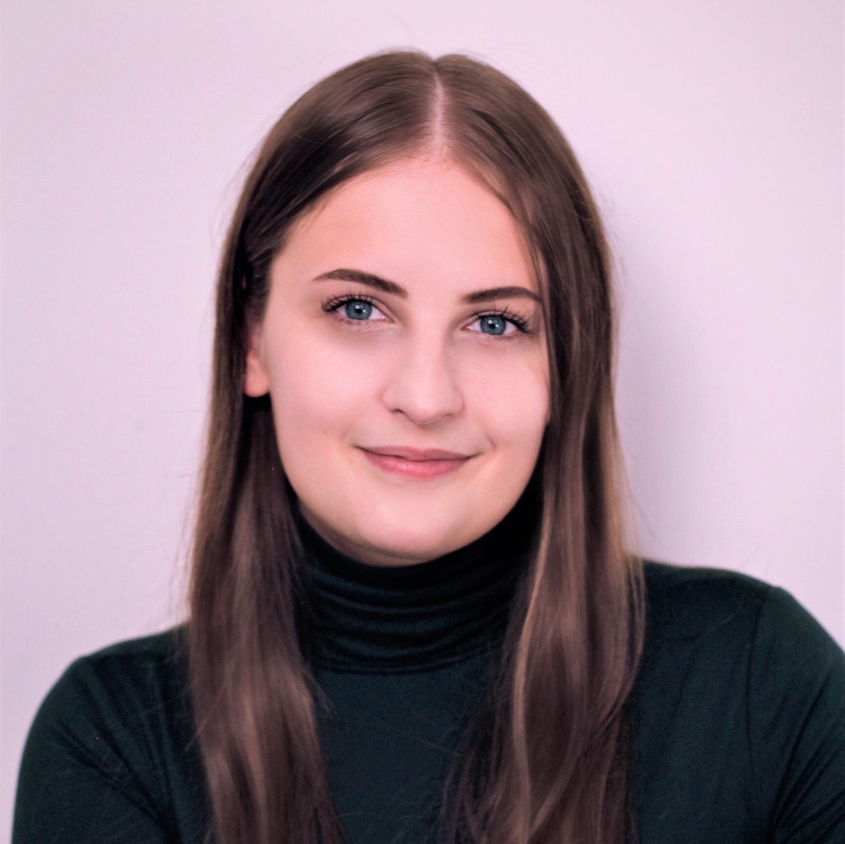 headshot of Nicole Paulescu, brunette wearing black turtleneck