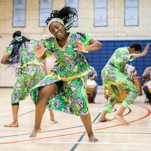 african american students wearing green attire and dancing