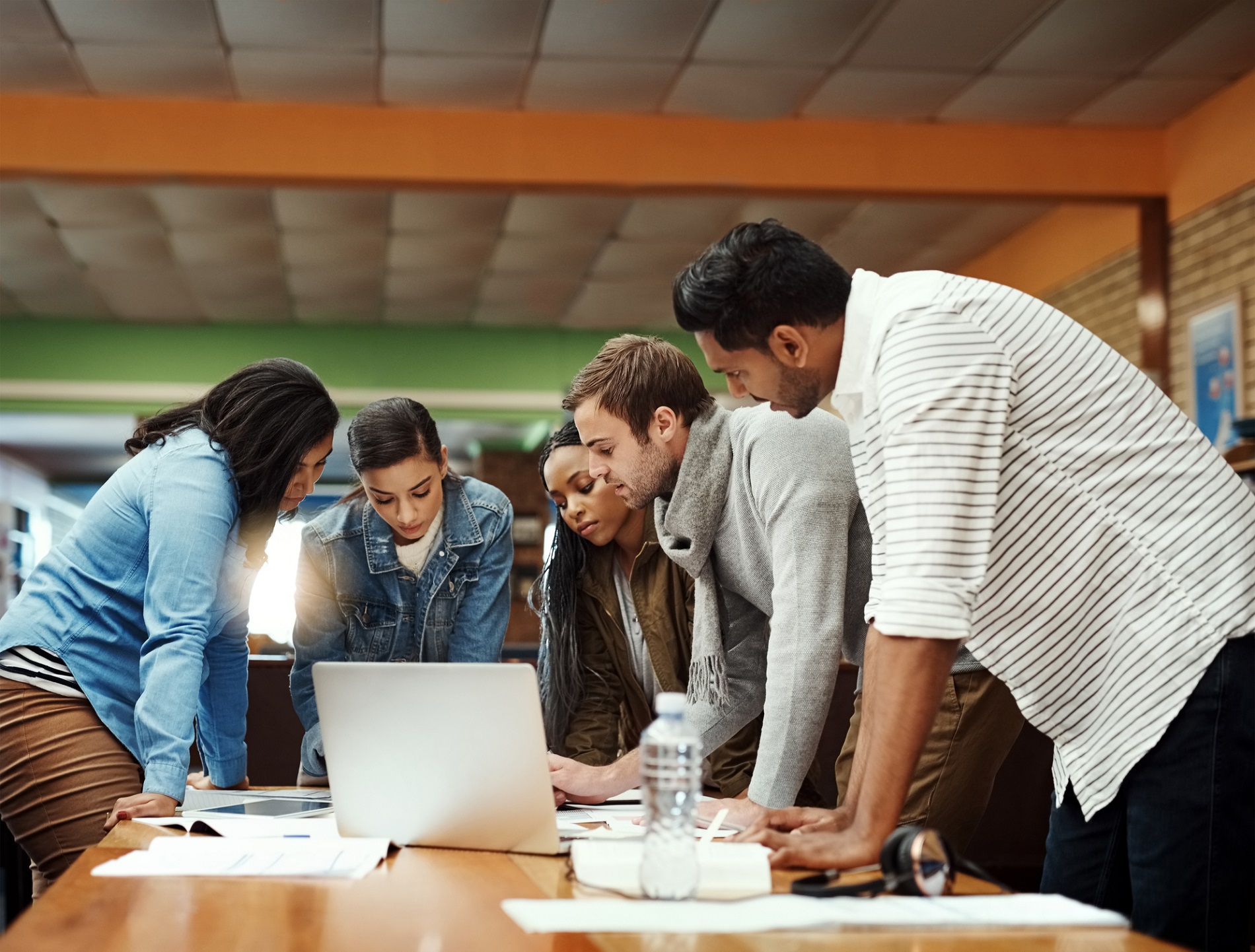 Students gather around a laptop